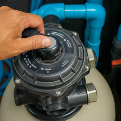 Father and son smiling at camera swimming underwater with swim goggles on