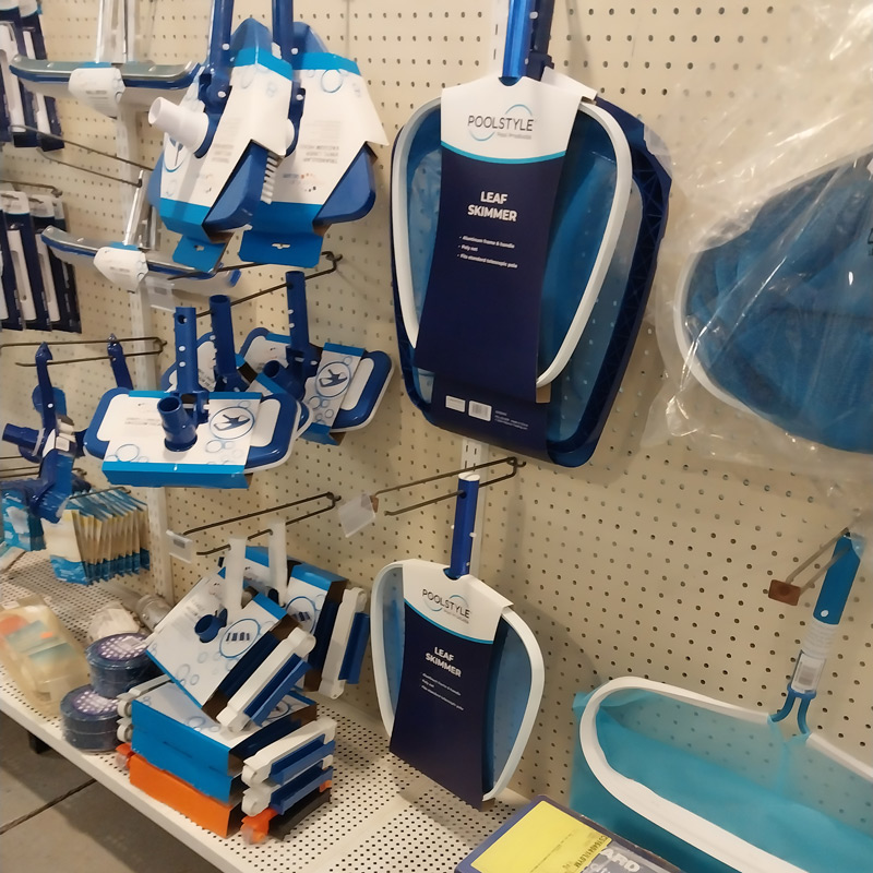 Display of pool cleaning equipment including leaf skimmers, scrubbing brushes, and pool vacuums at Greeneville retail store