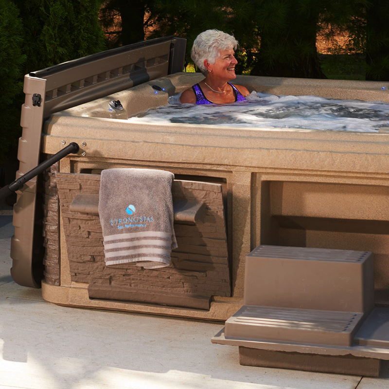 Strong Spas G2 series spa with fold out towel holder and steps in use