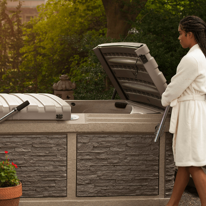 Woman opening a Strong Spas DURA-SHIELD Hardcover with a lift assist arm