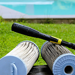 Father and son smiling at camera swimming underwater with swim goggles on